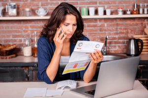 A woman with a broken leg is looking at her medical bill and frustrated on the phone