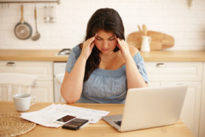 woman with financial stress poring over bills