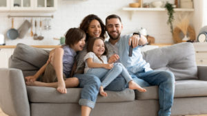 smiling young family on couch at home