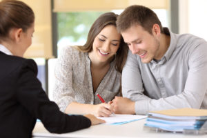 happy couple signing loan paperwork