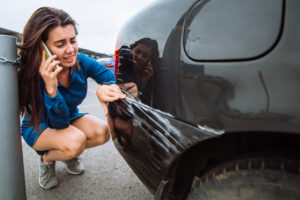 woman standing near scratched auto