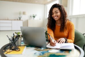 young black woman happily taking notes for application