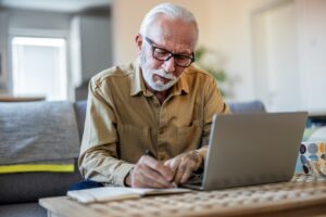 man writing out his bills