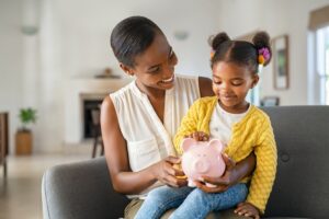 mom and daughter with piggy bank