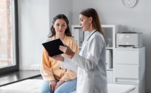 woman reviewing medical results on a device with her doctor