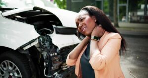 woman with a neck injury, wondering how to pay for medical treatment after a car accident.